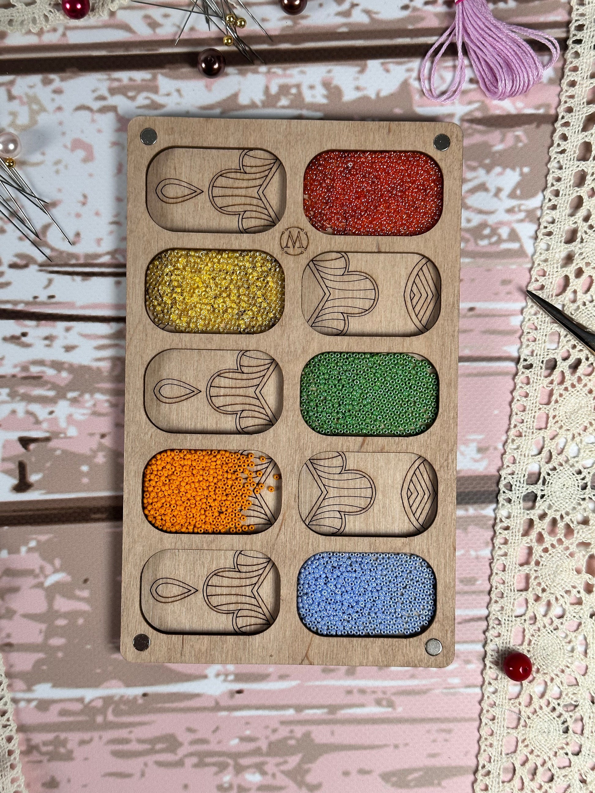 a picture of a wooden board with different colors of beads