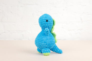 a crocheted blue and green toy sitting on a table