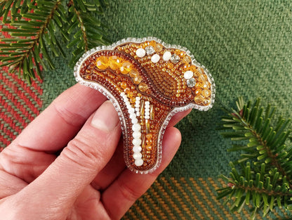 a hand holding a beaded brooch in the shape of a horse