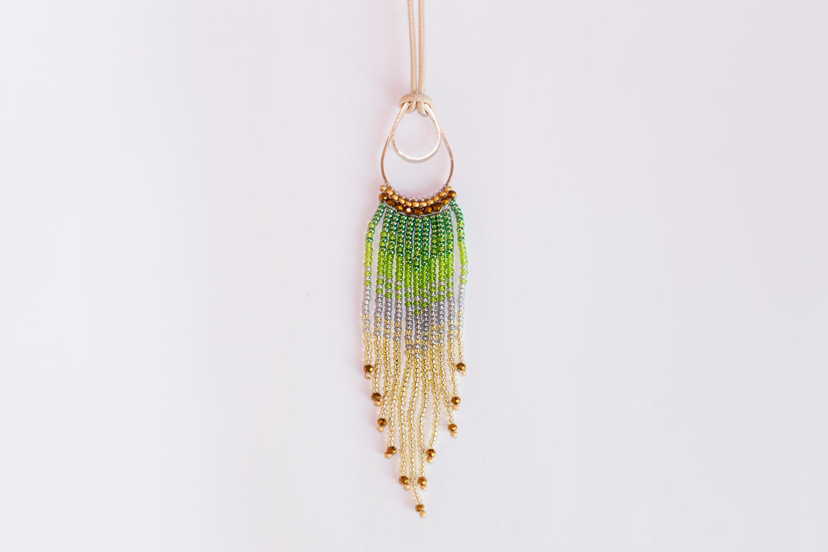A beaded necklace with a large circular pendant featuring a gradient of green, purple, and yellow beads.