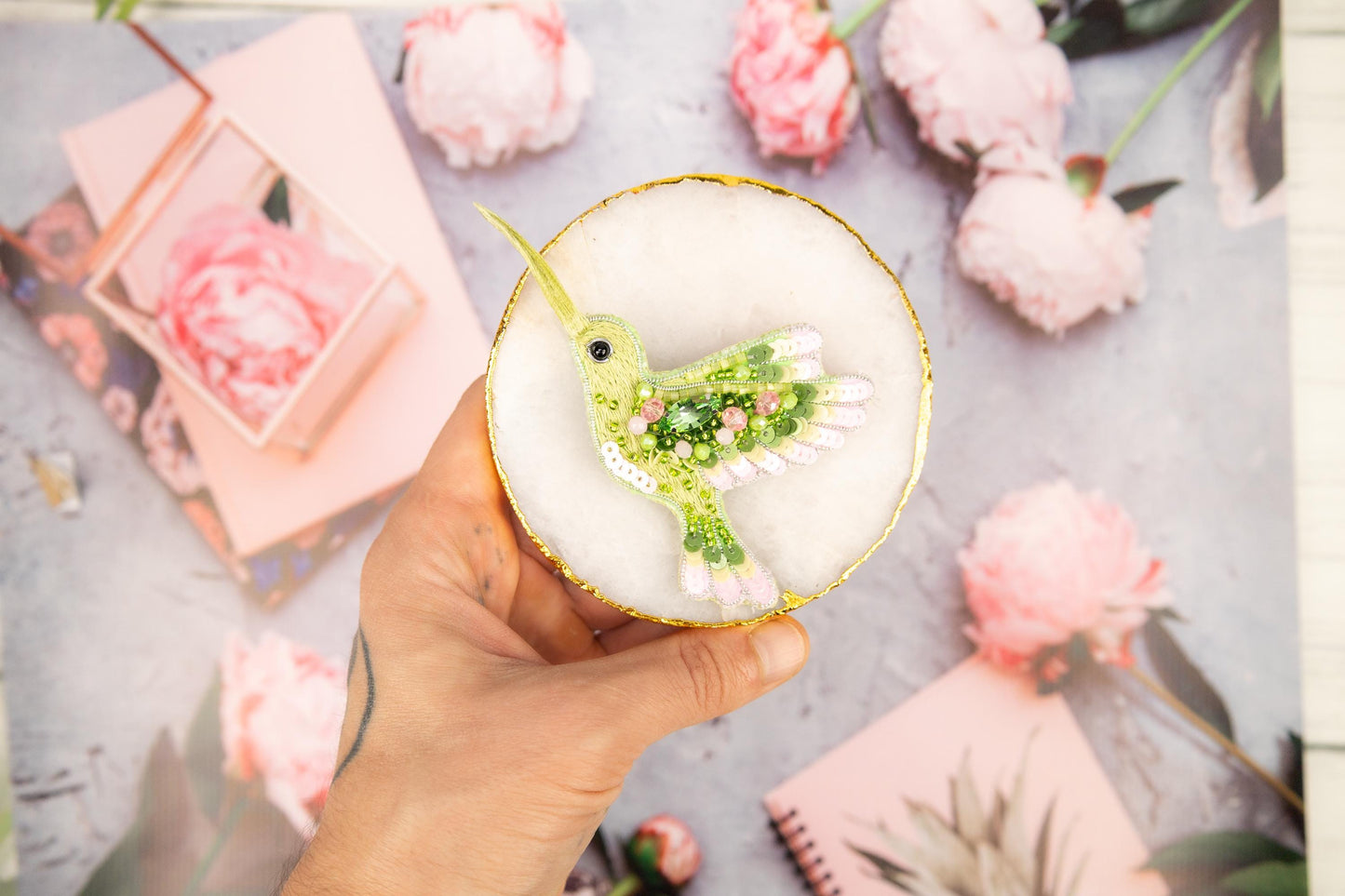 a person holding a drink with a bird decoration on it