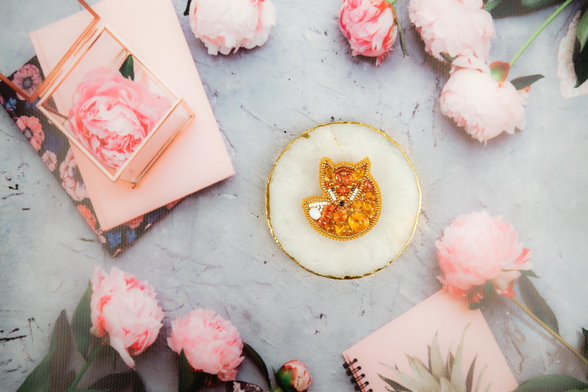 a cat brooch sitting on top of a white plate