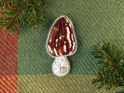 a crocheted object sitting on top of a table next to a pine tree