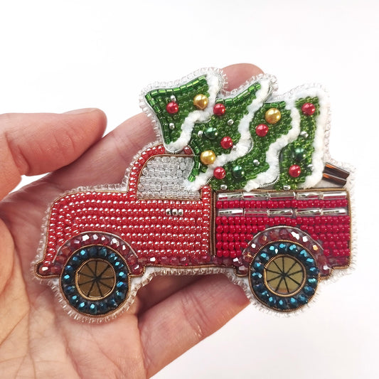 a hand is holding a christmas truck ornament