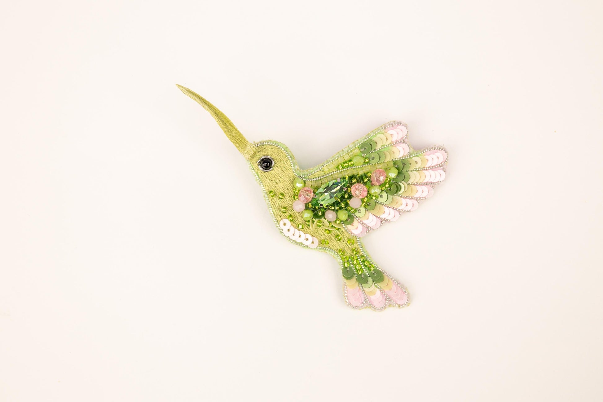 a green bird with pink flowers on its wings