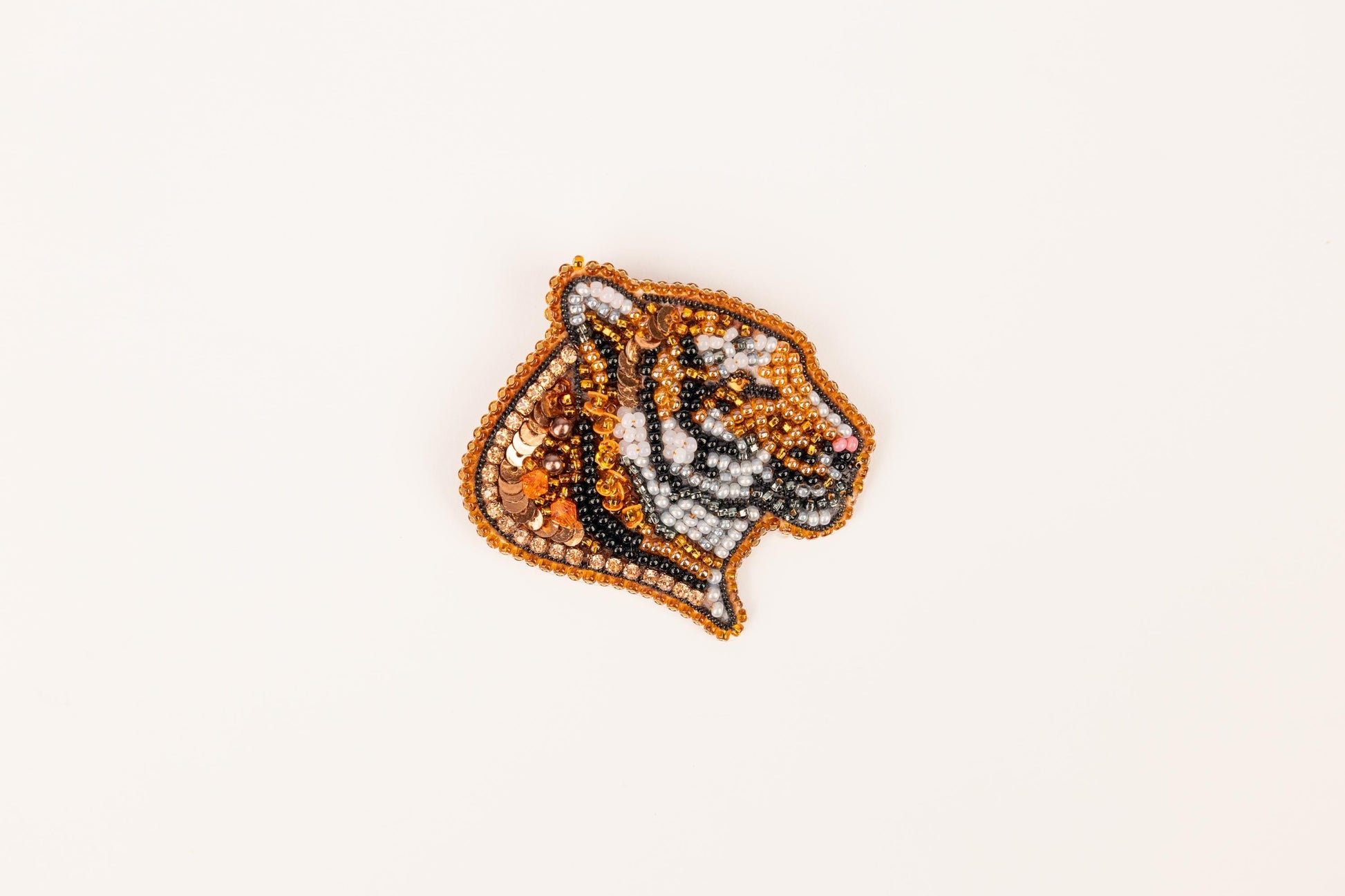 a beaded tiger head on a white background
