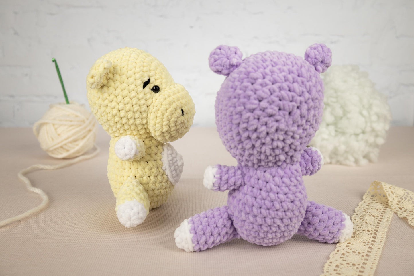 two crocheted stuffed animals sitting next to a ball of yarn