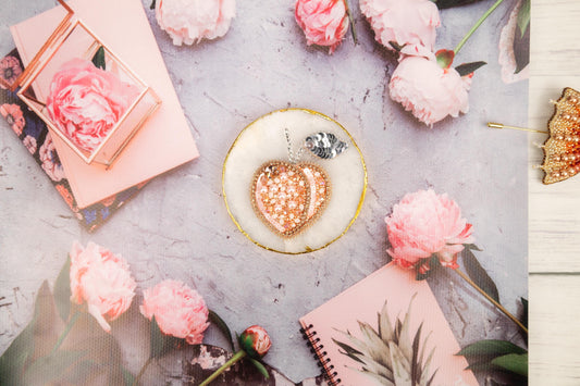 a table topped with pink flowers and a heart shaped object