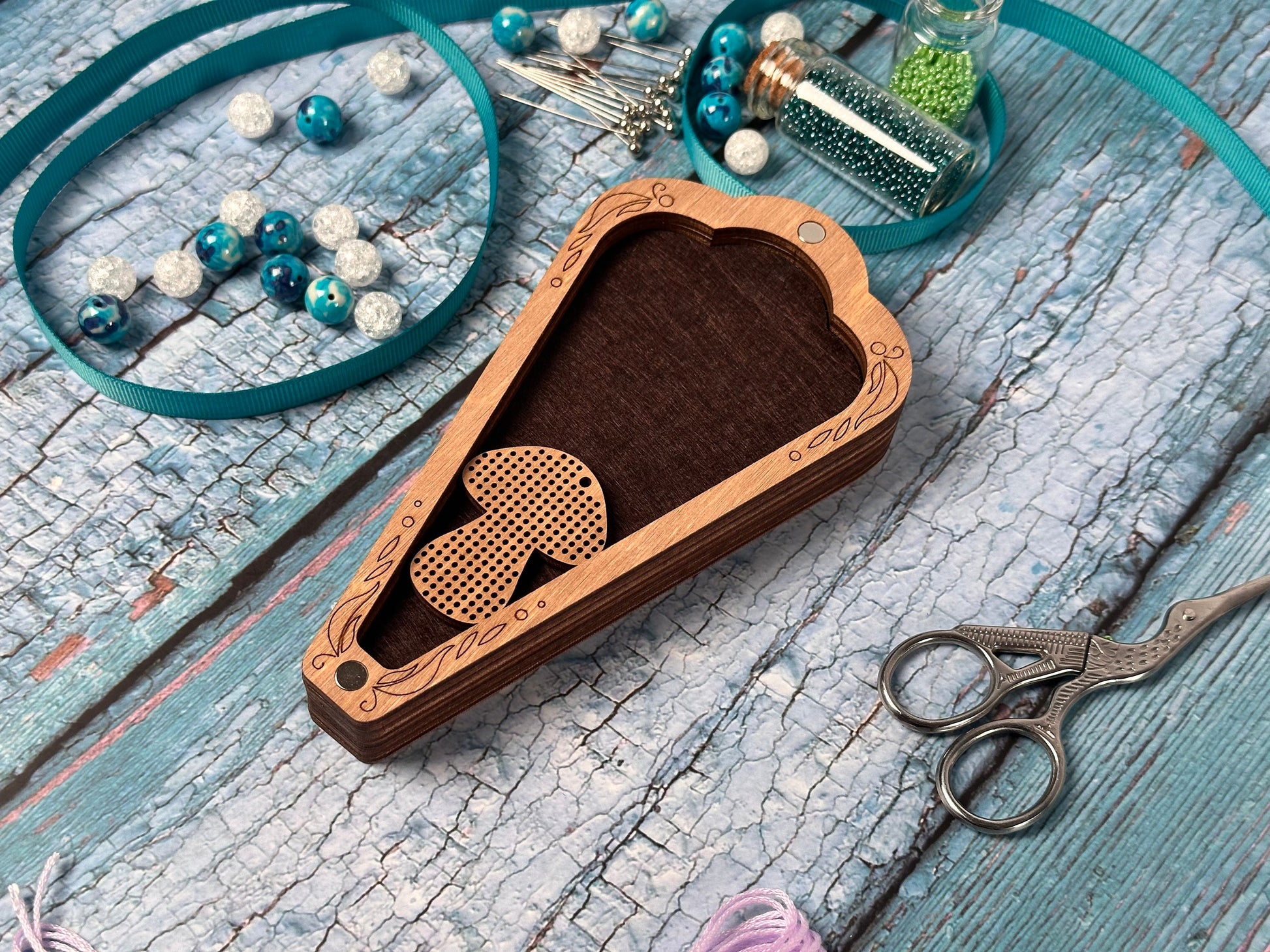 a pair of scissors and some beads on a table