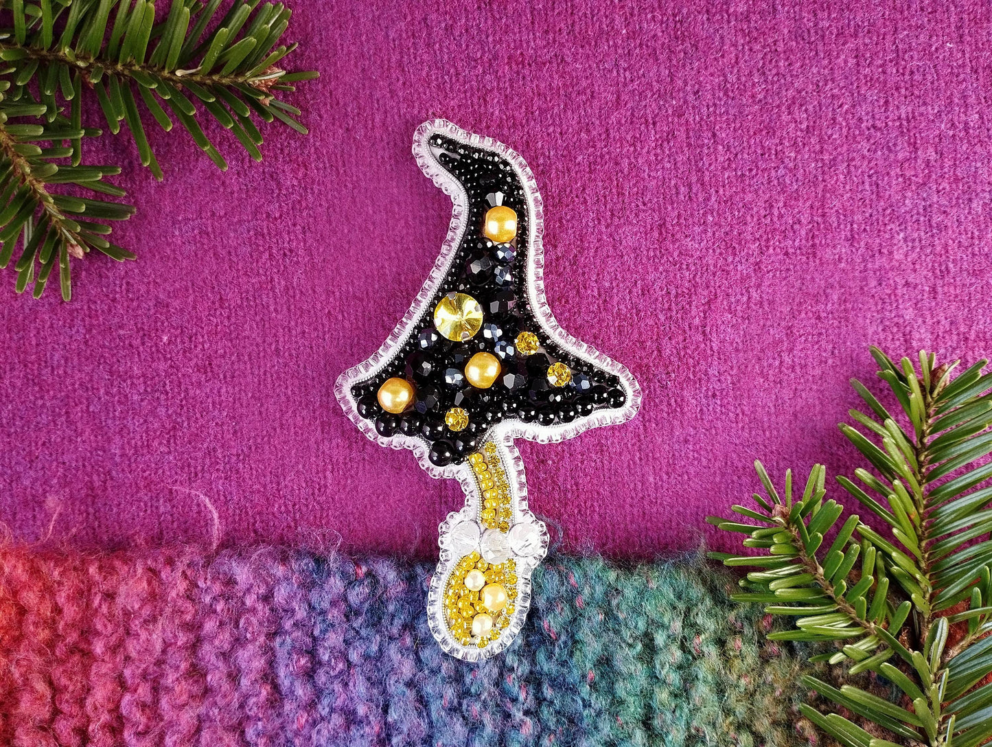 a knitted christmas tree ornament on a purple background