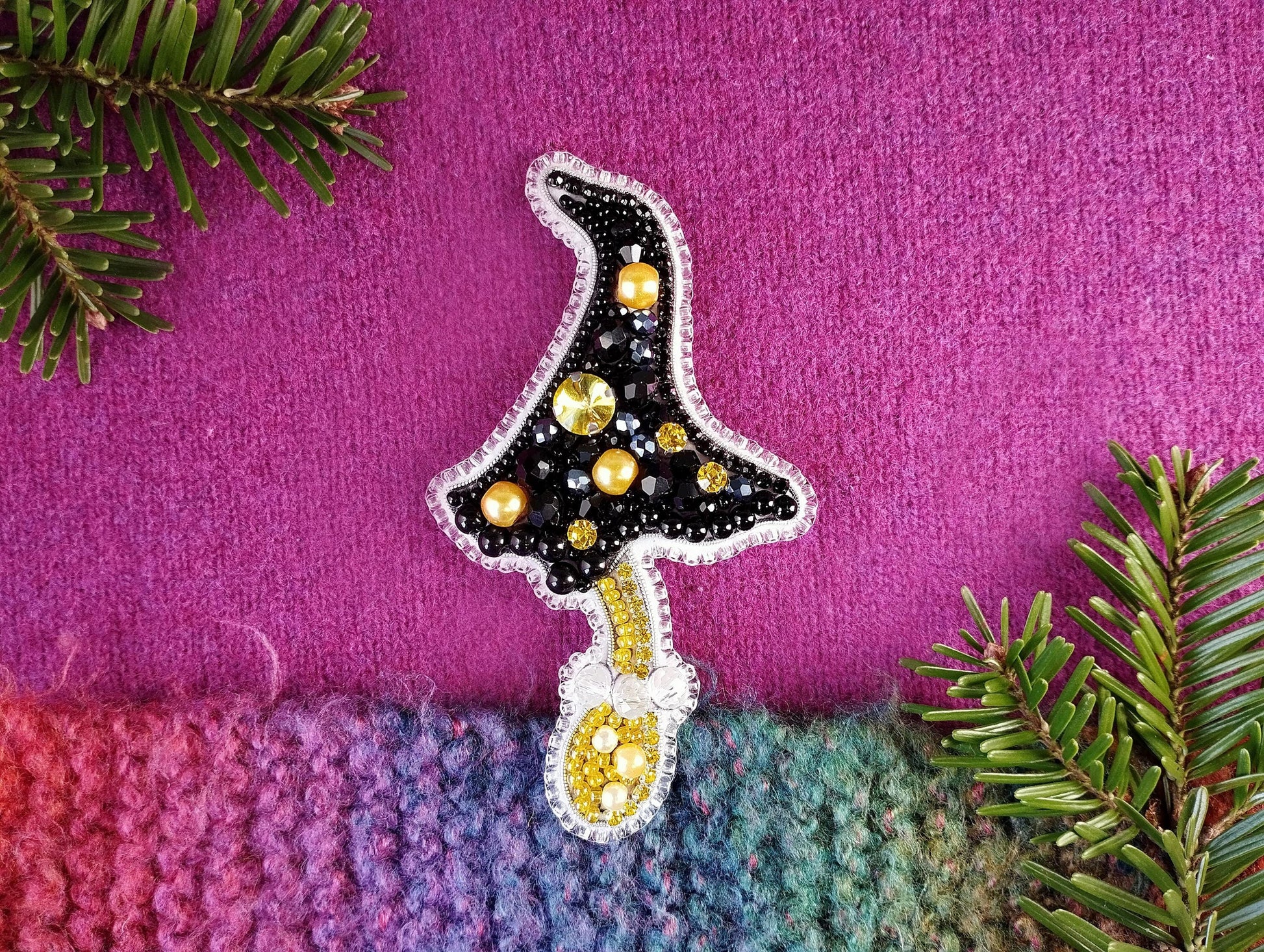 a knitted christmas tree ornament on a purple background