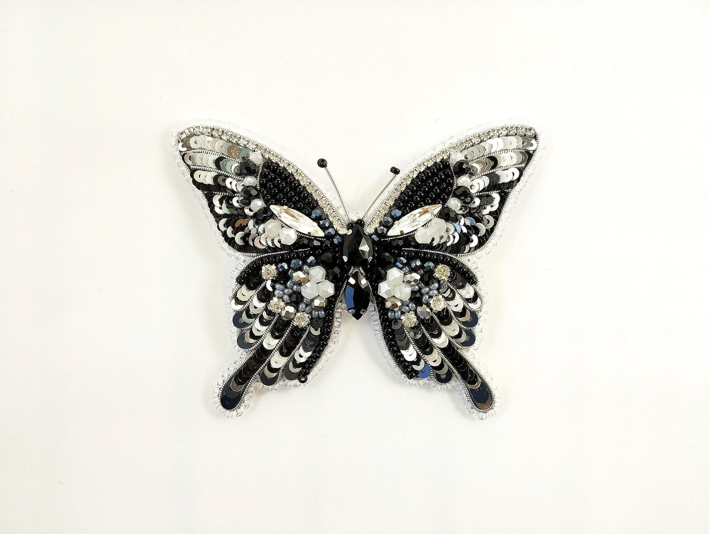 a black and white butterfly brooch on a white background