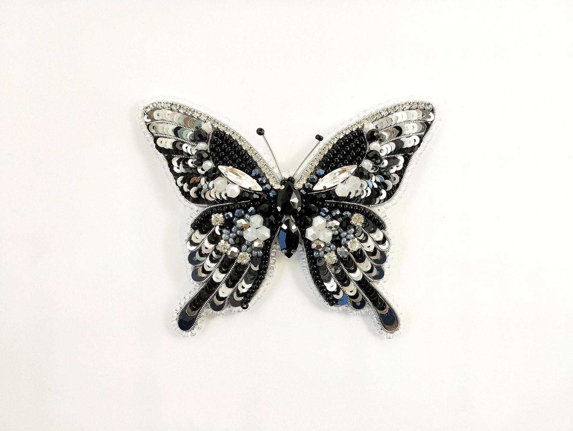 a black and white butterfly brooch on a white background