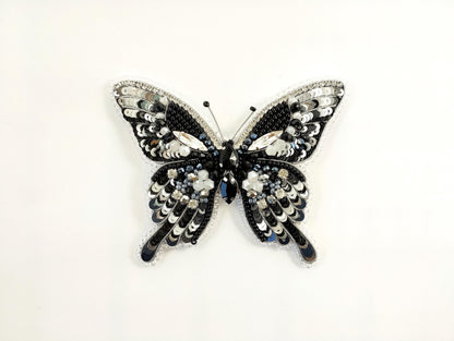 a black and white butterfly brooch on a white background