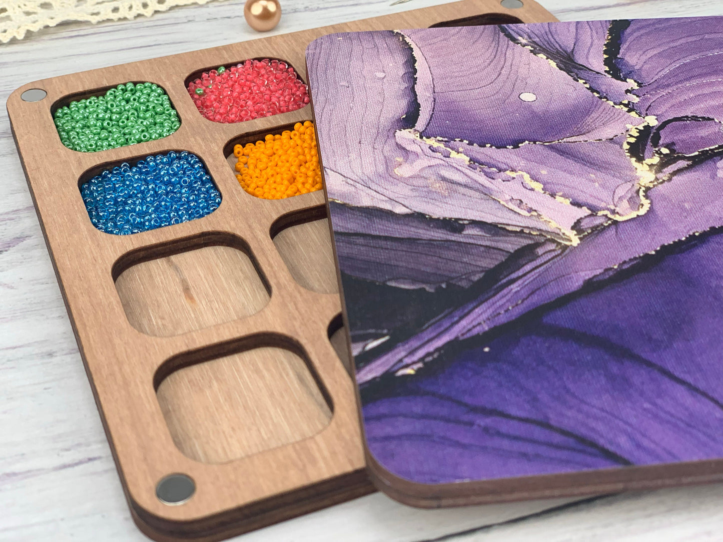 a wooden box with beads in it next to a picture of a butterfly