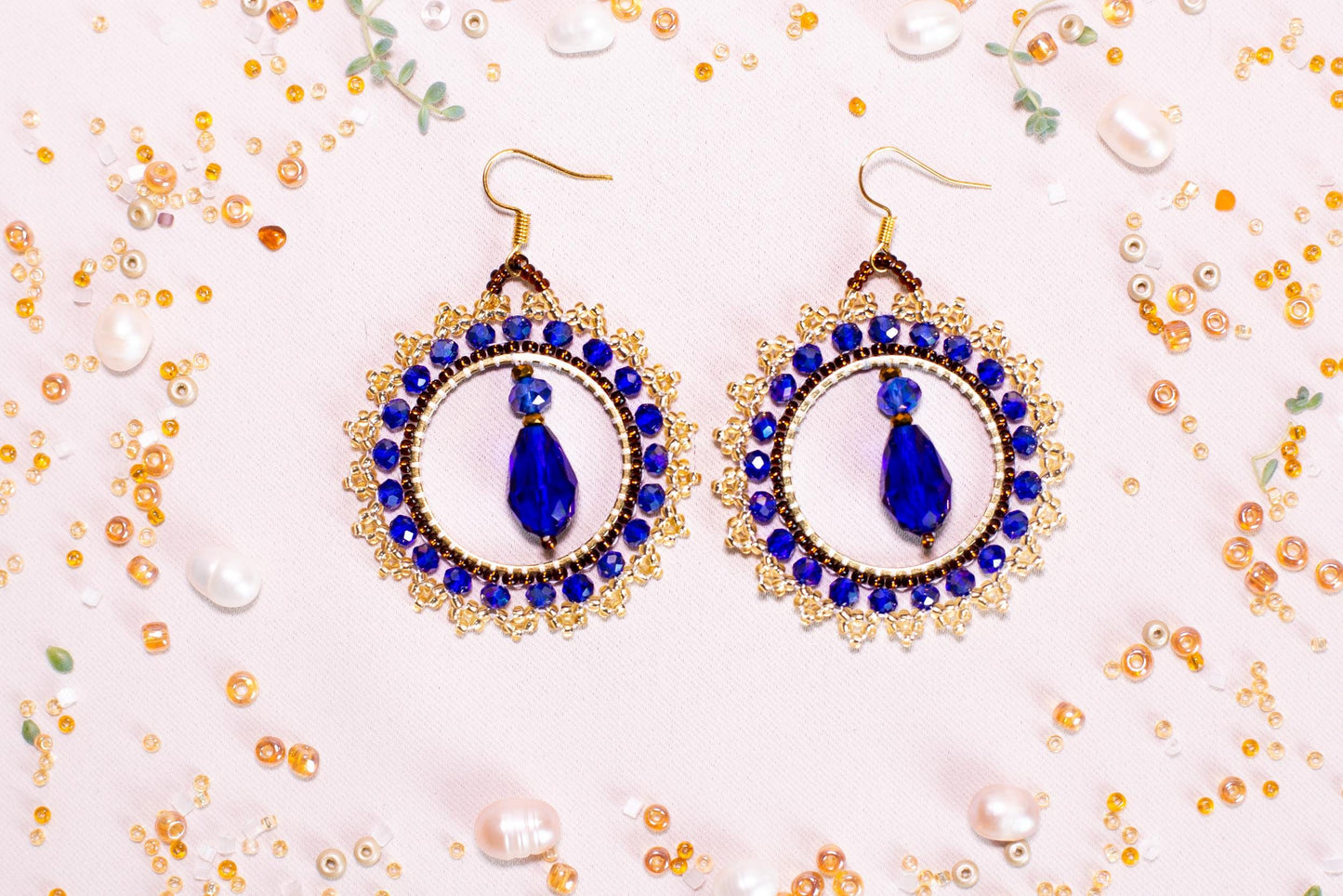 a pair of blue and white earrings on a table