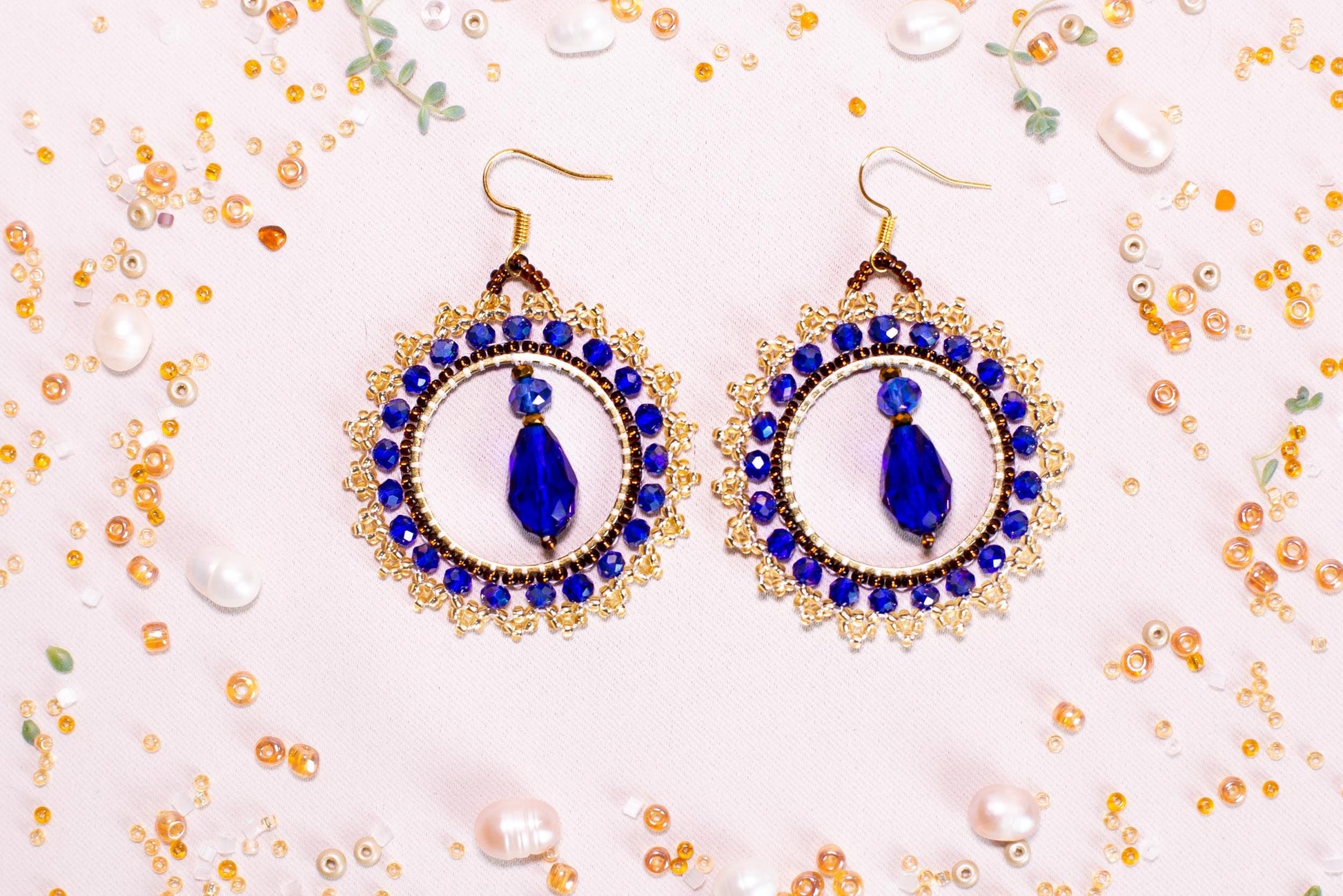 a pair of blue and white earrings on a table