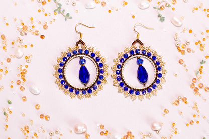 a pair of blue and white earrings on a table