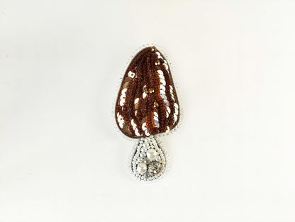 a brown and white beaded object on a white surface