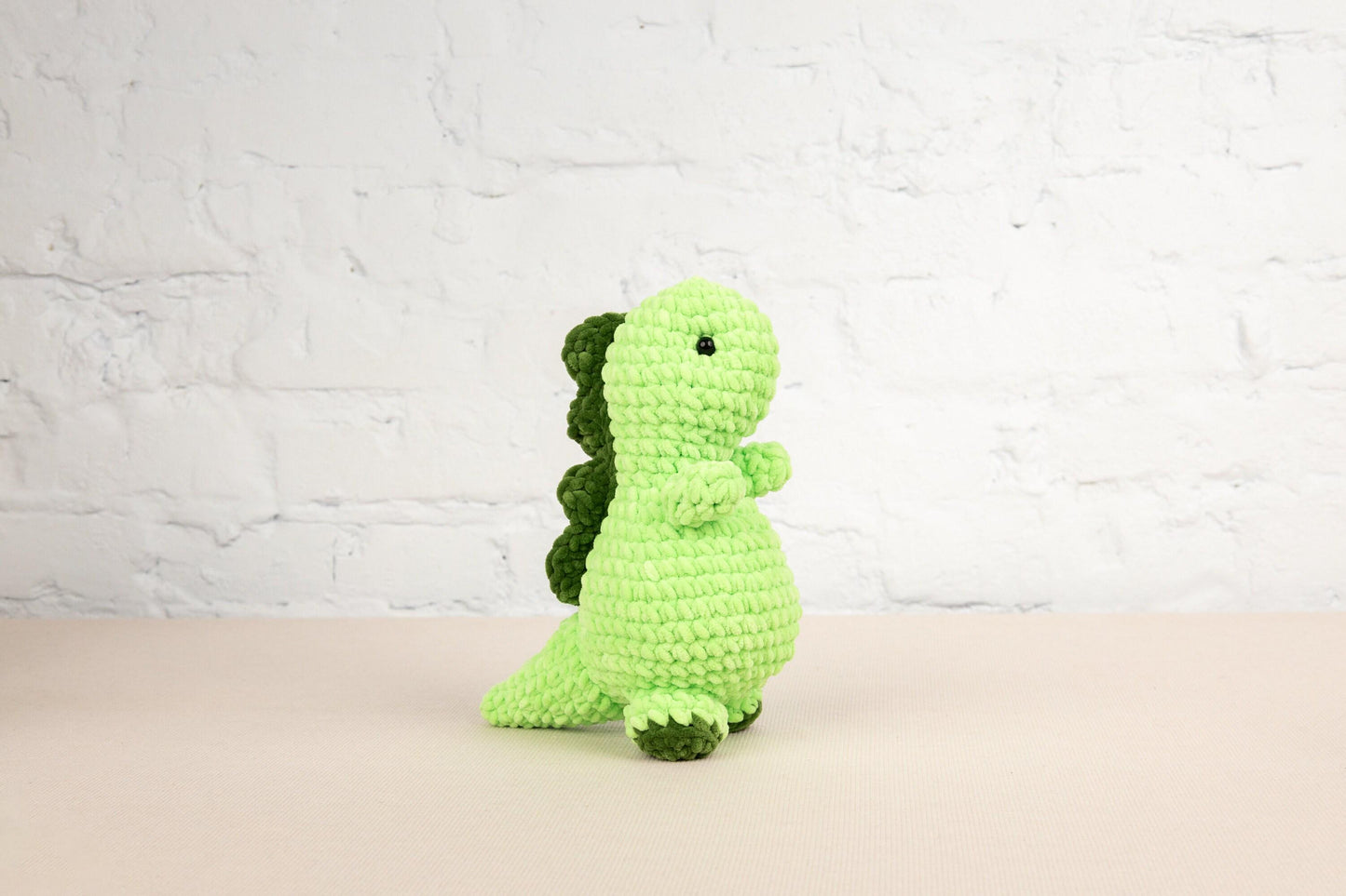 a green crocheted toy sitting on a table