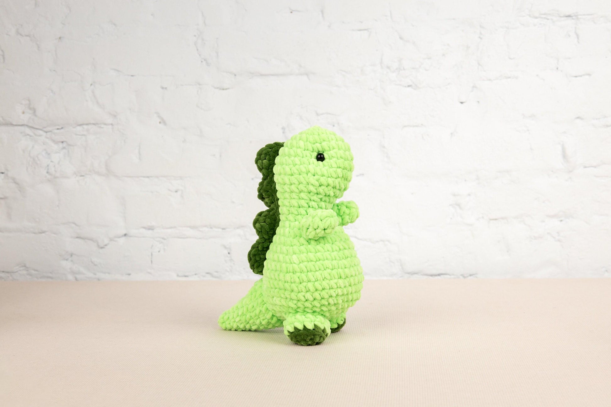 a green crocheted toy sitting on a table