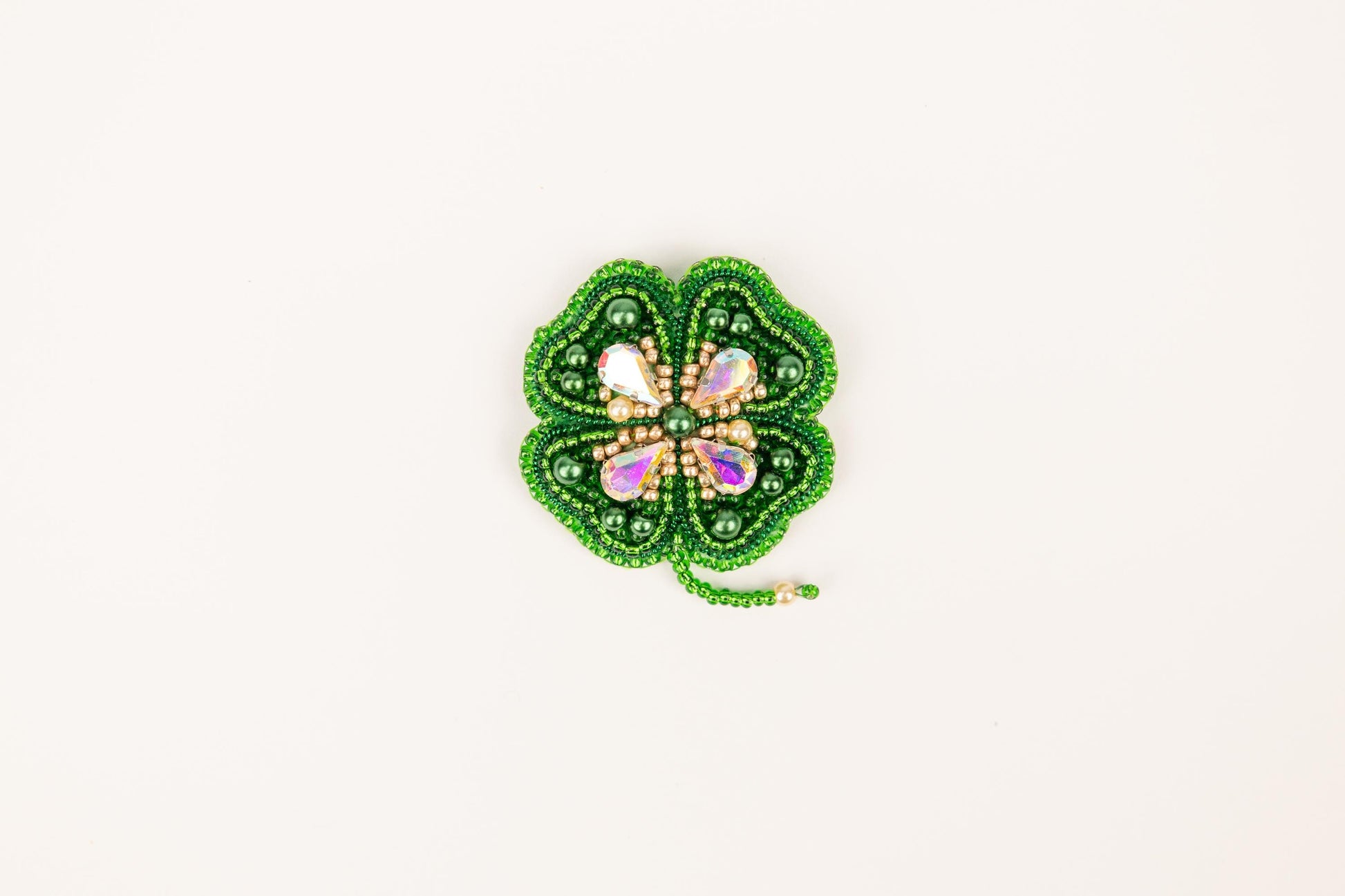 a green beaded brooch with a butterfly on it