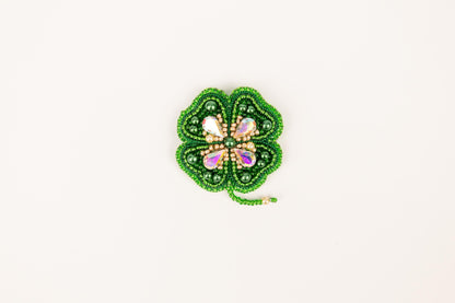a green beaded brooch with a butterfly on it