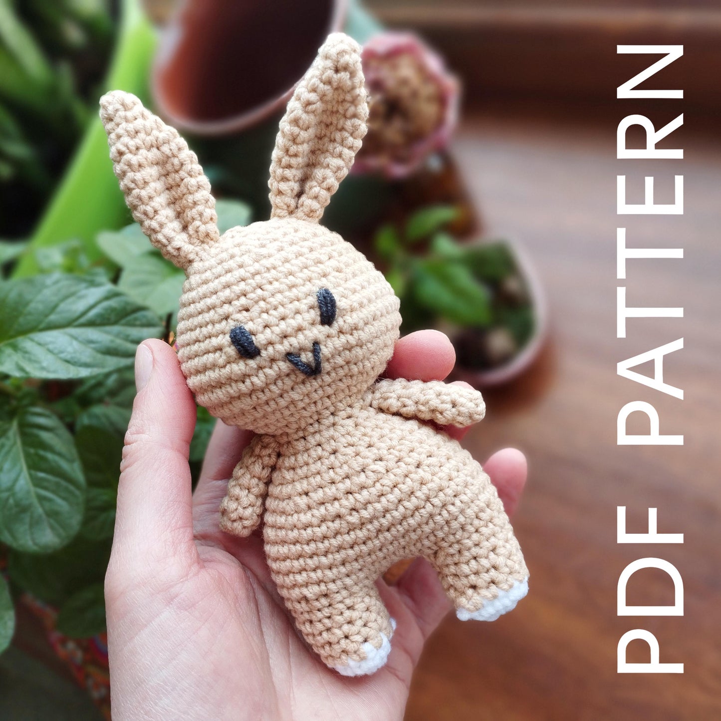 a hand holding a small crocheted stuffed animal