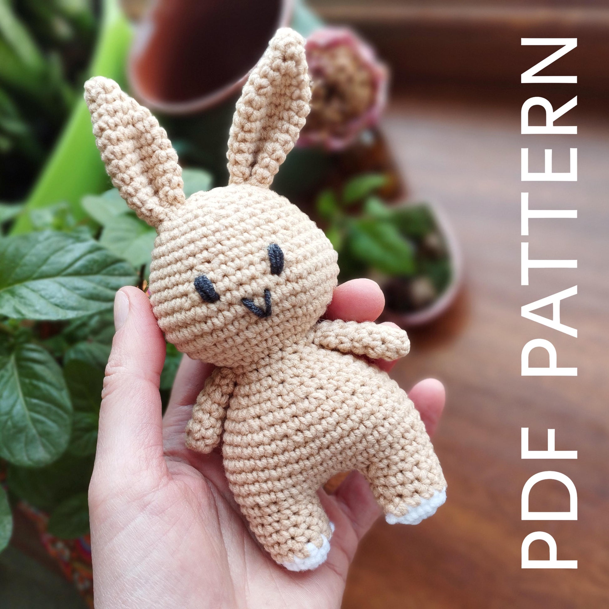 a hand holding a small crocheted stuffed animal