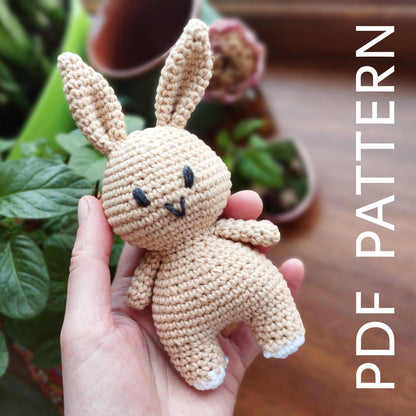 a hand holding a small crocheted stuffed animal