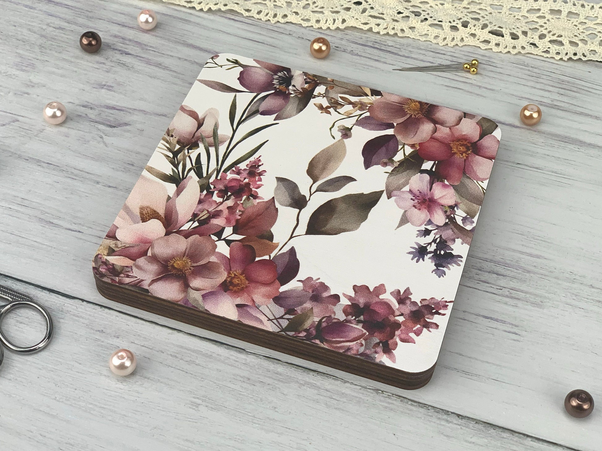 a notebook with a floral design on it next to a pair of scissors
