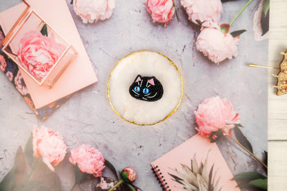a cake with a black cat on top of it