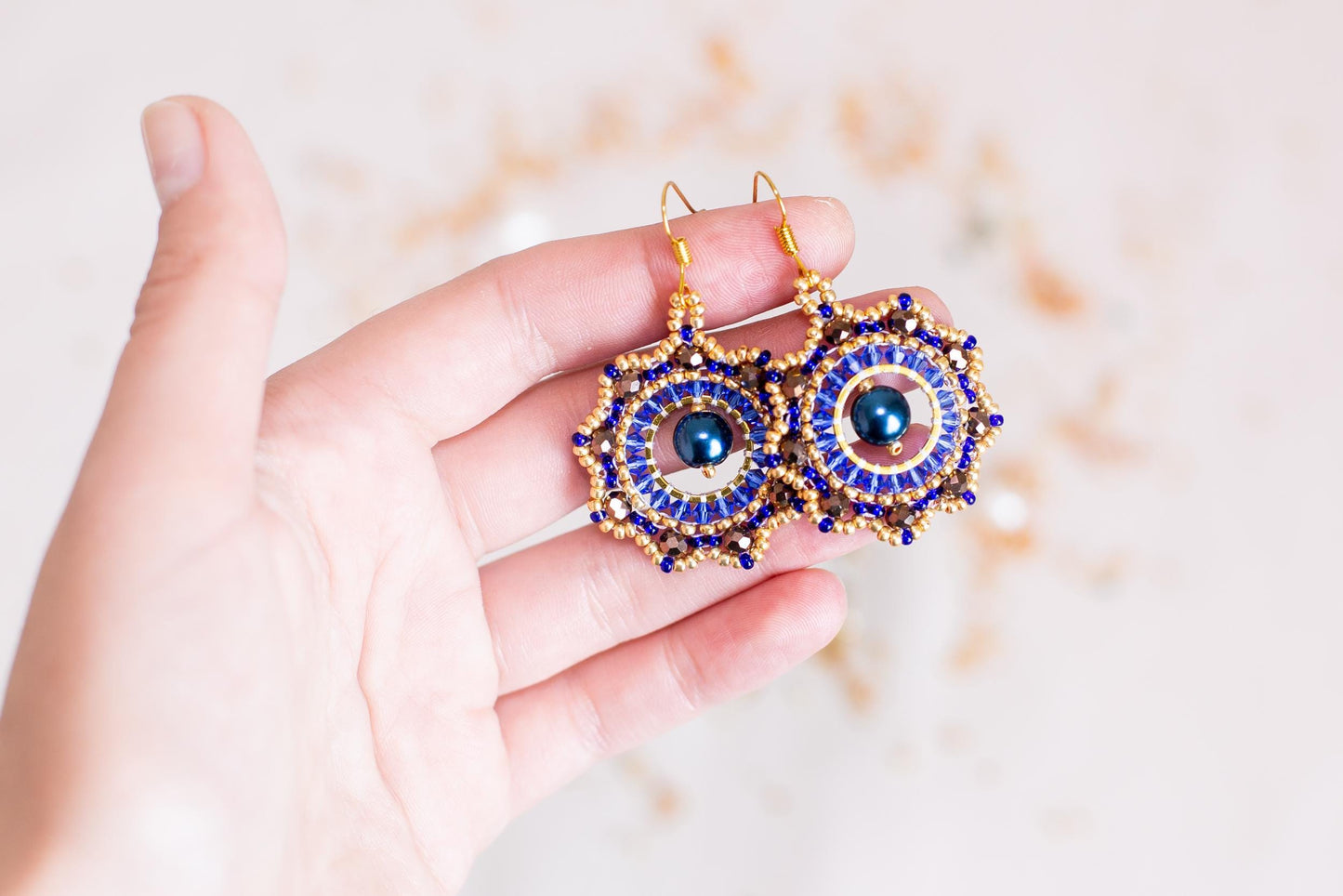 a person holding a pair of earrings in their hand