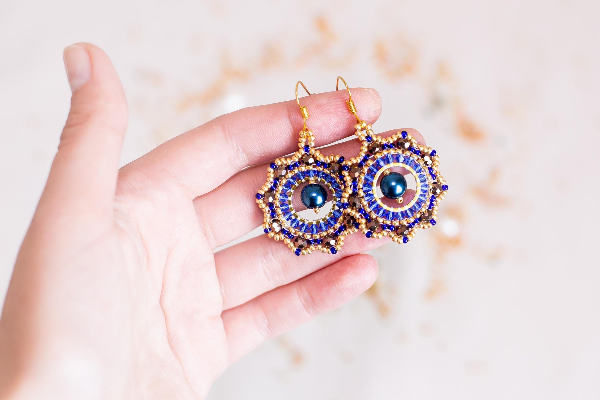 a person holding a pair of earrings in their hand