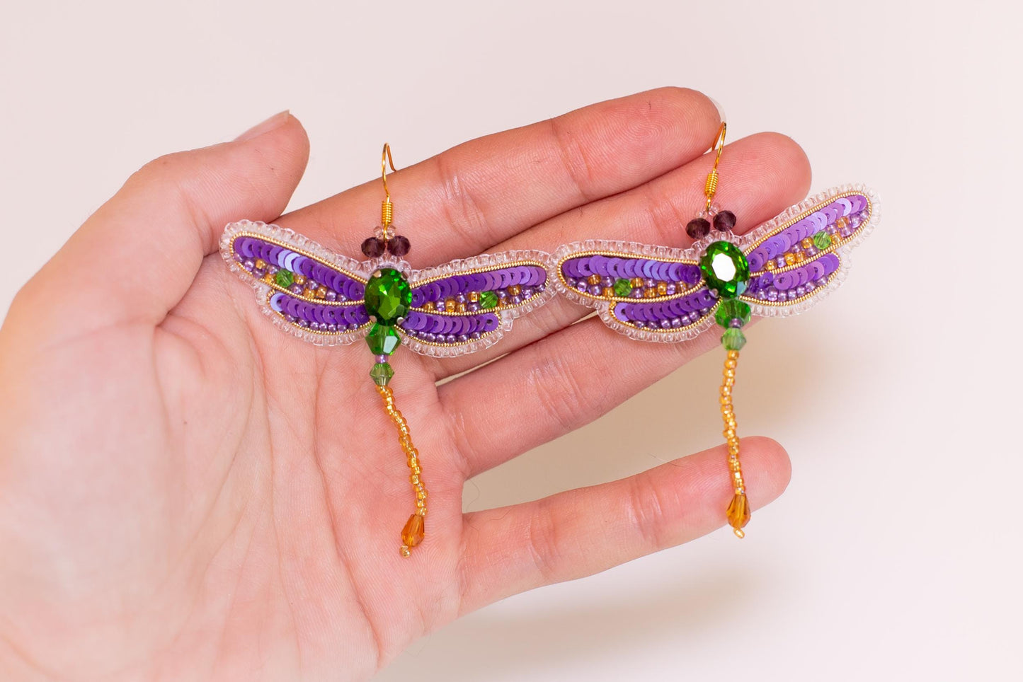 a person holding a pair of earrings in their hand