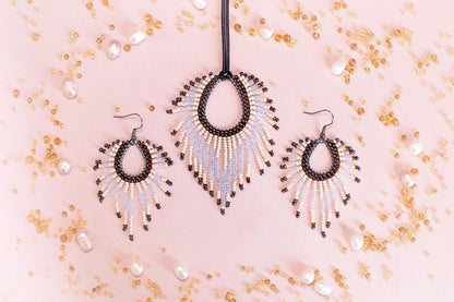 a necklace and earrings set with beaded designs, including a pendant and earrings, against a pink background with scattered pearls and beads.