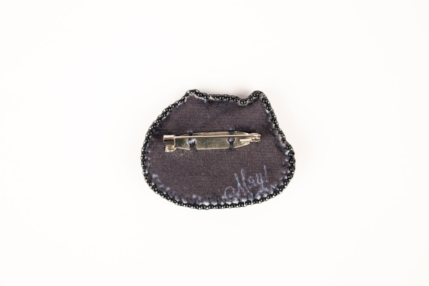 a small black purse with a small metal object on it