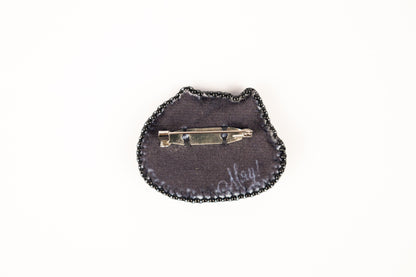 a small black purse with a small metal object on it