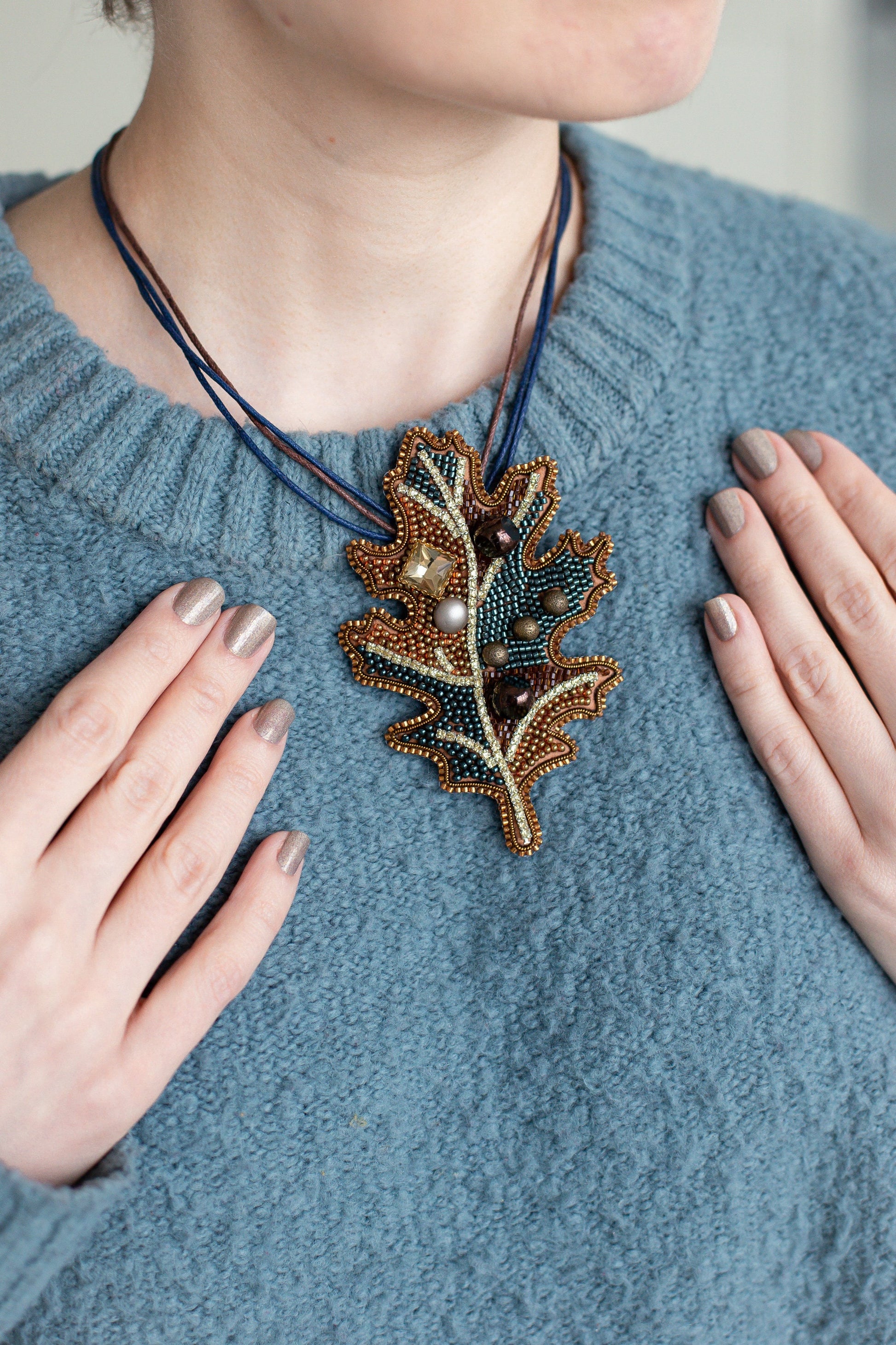 a woman wearing a blue sweater and a necklace
