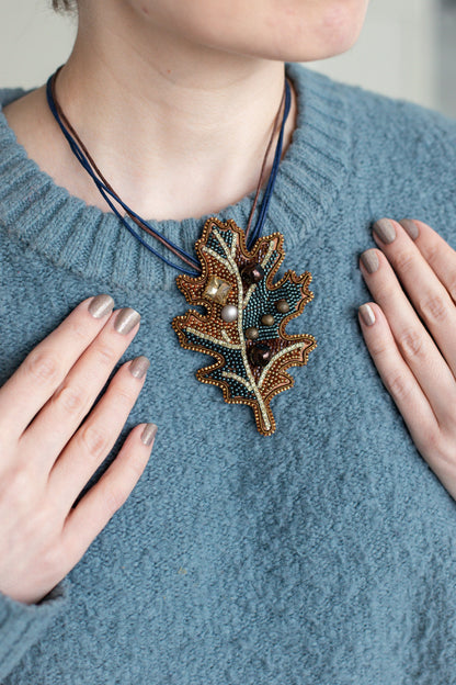 a woman wearing a blue sweater and a necklace