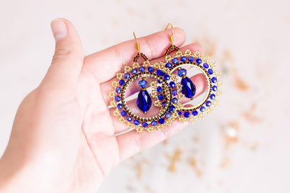 a person holding a pair of earrings in their hand