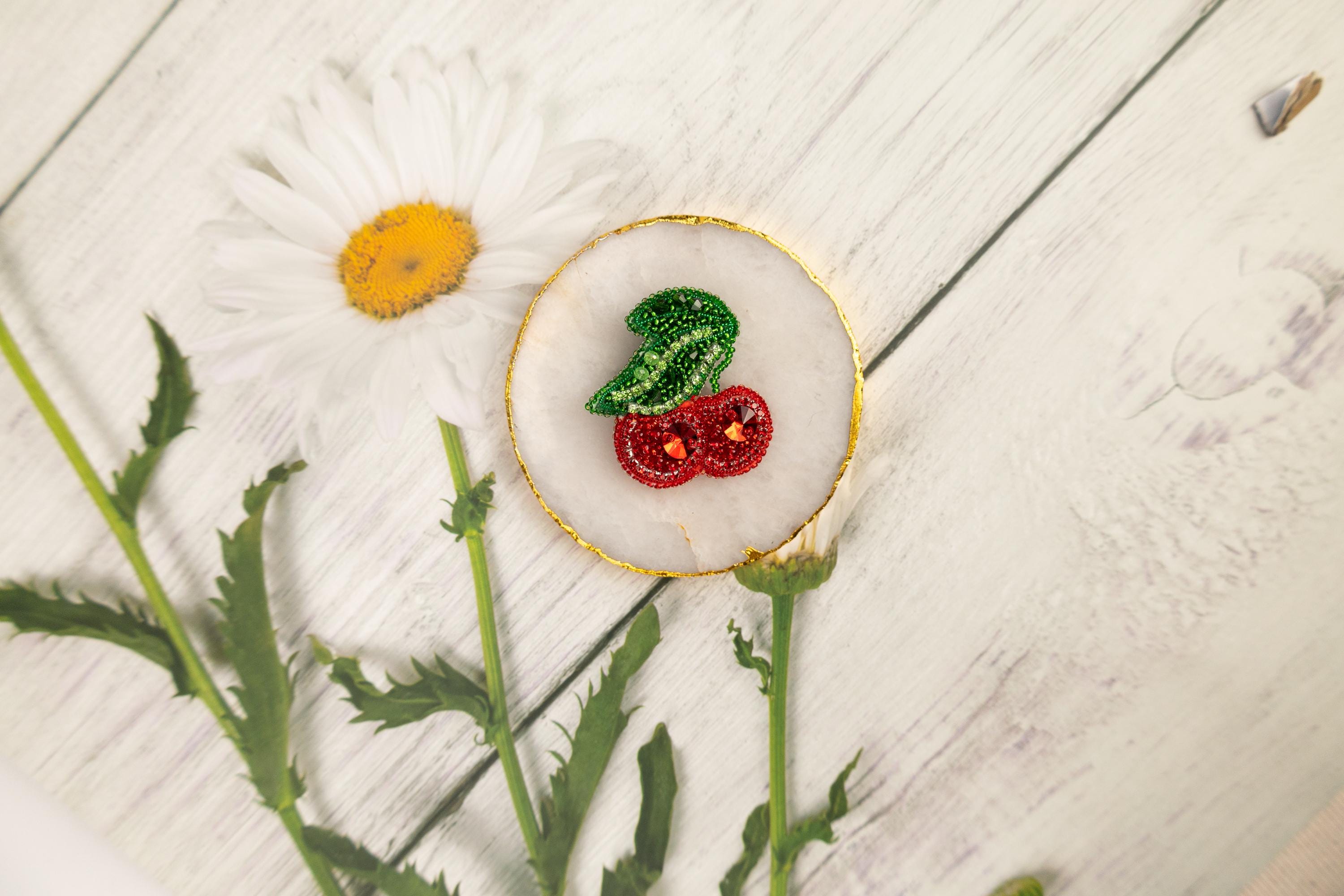 a white flower and some green leaves on a white table