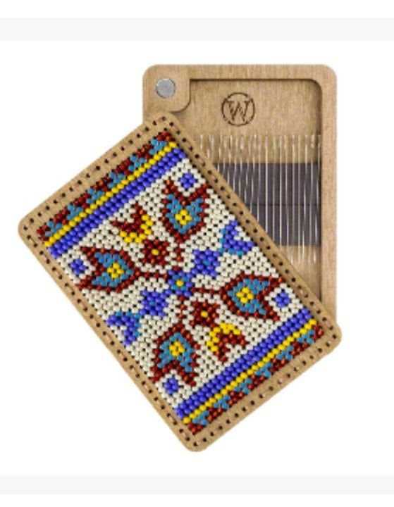 a piece of wood with a needle and a needle holder