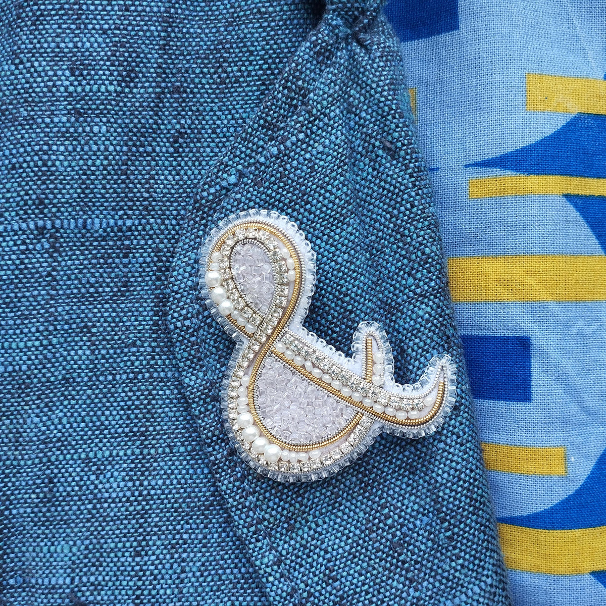 a close-up view of a blue fabric with a decorative element, possibly a brooch or pin, attached to it.