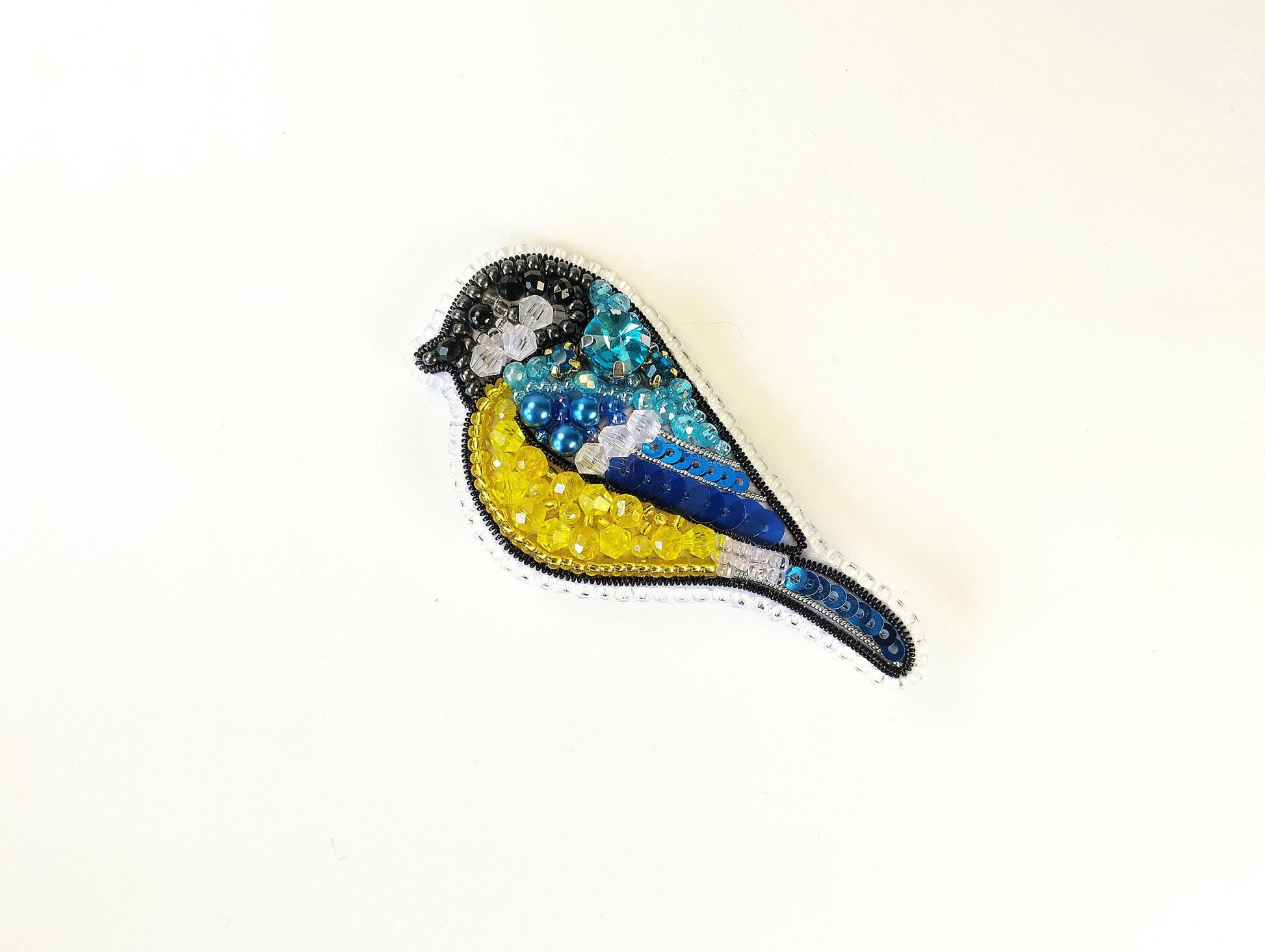 a blue and yellow bird sitting on top of a white wall