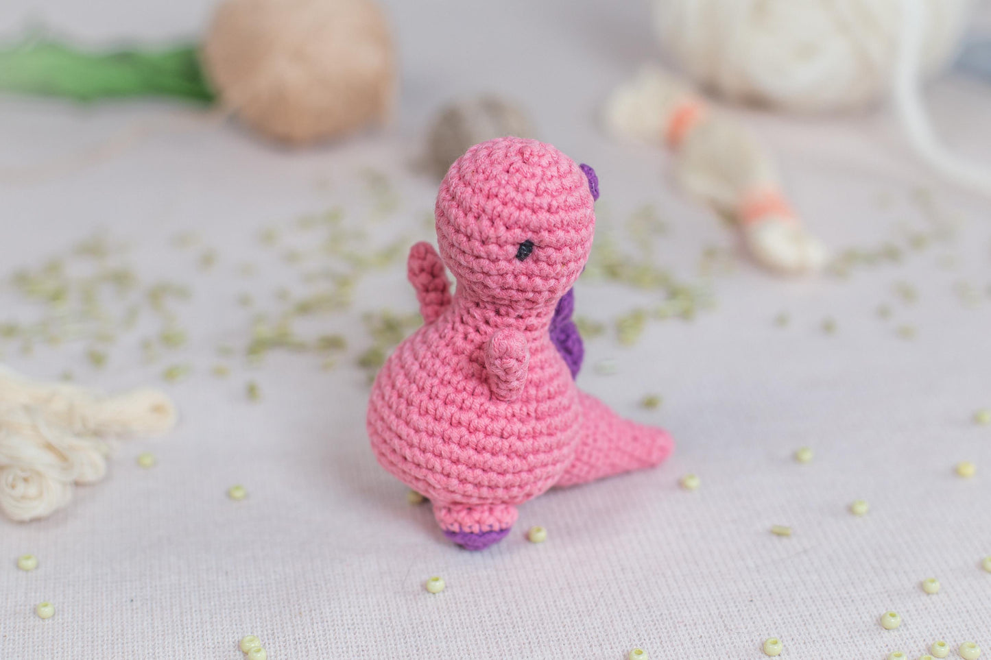 a pink crocheted toy sitting on top of a table