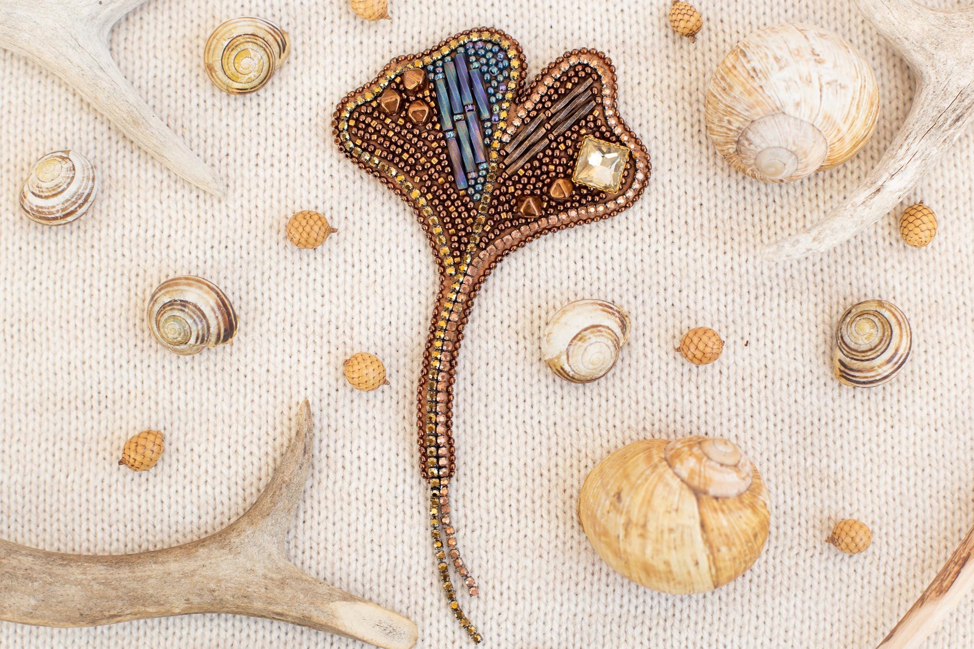 a variety of natural elements, including shells, antlers, and a decorative piece, arranged on a textured surface.