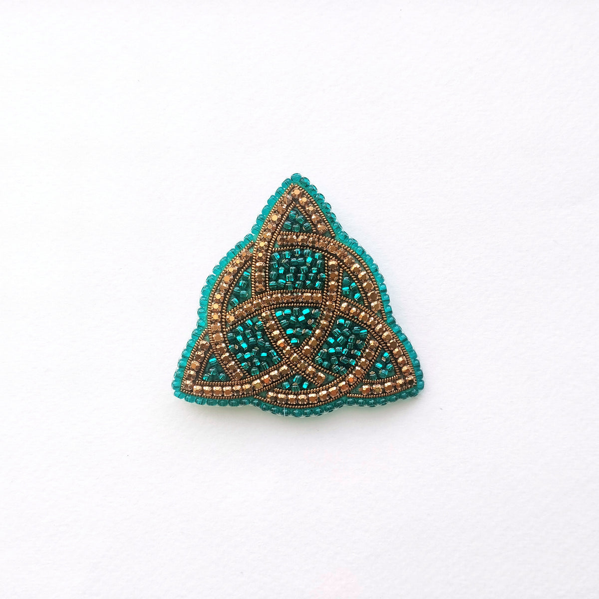 A triangular piece of jewelry with a beaded design, featuring a combination of blue and gold colors.