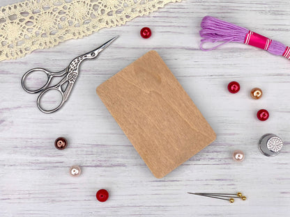 a wooden cutting board surrounded by sewing supplies
