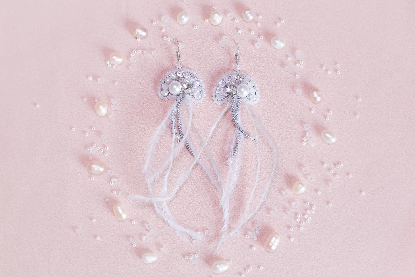a pair of white bowknots with pearls on a pink background